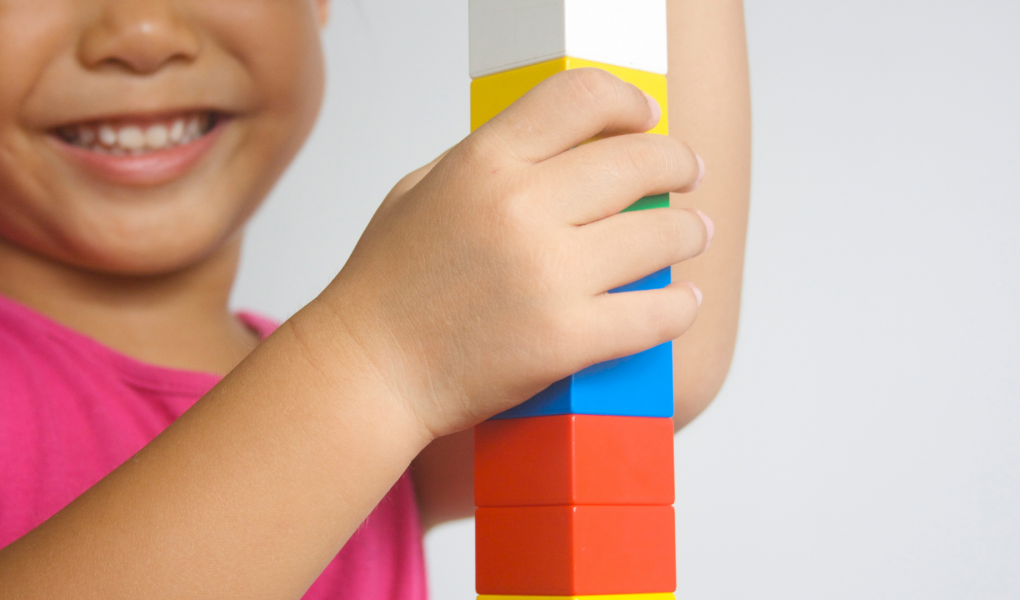 child playing with colored building blocks