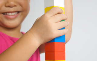 child playing with colored building blocks