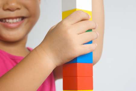 child playing with colored building blocks